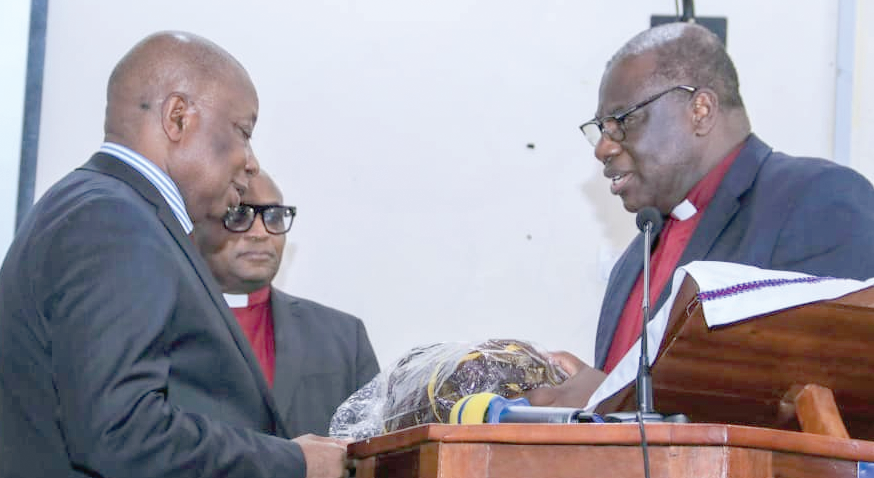 Rt Rev. Professor Joseph Obiri Yeboah Mante (right) presenting some souvenirs to Kwaku Agyemang-Manu 